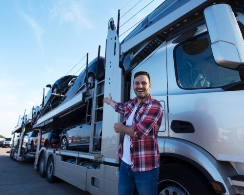 middle-aged-trucker-front-truck-trailer-with-cars_342744-1283